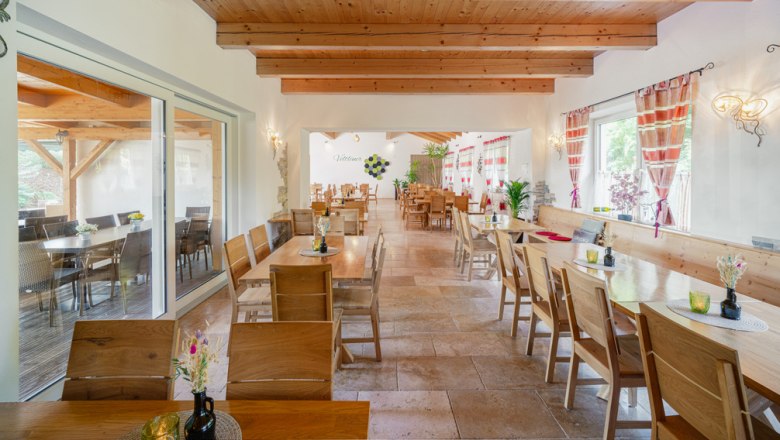 Gemütlichkeit beim Weinviertler Heurigen, © Martin Mathes Innenansicht eines gemütlichen Heurigenlokals mit Holzmöbeln und dekorativen Vorhängen.