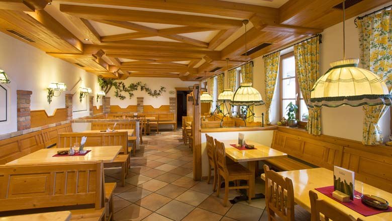 Heurigenlokal, © Weingut Deutsch Innenansicht eines traditionellen Heurigenlokals mit Holzmöbeln und gemütlicher Beleuchtung.