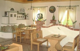 Heuriger Lahrnsteig, © Familie Lahrnsteig Gemütlicher Innenraum eines Heurigen mit Holzmöbeln und dekorativen Elementen.