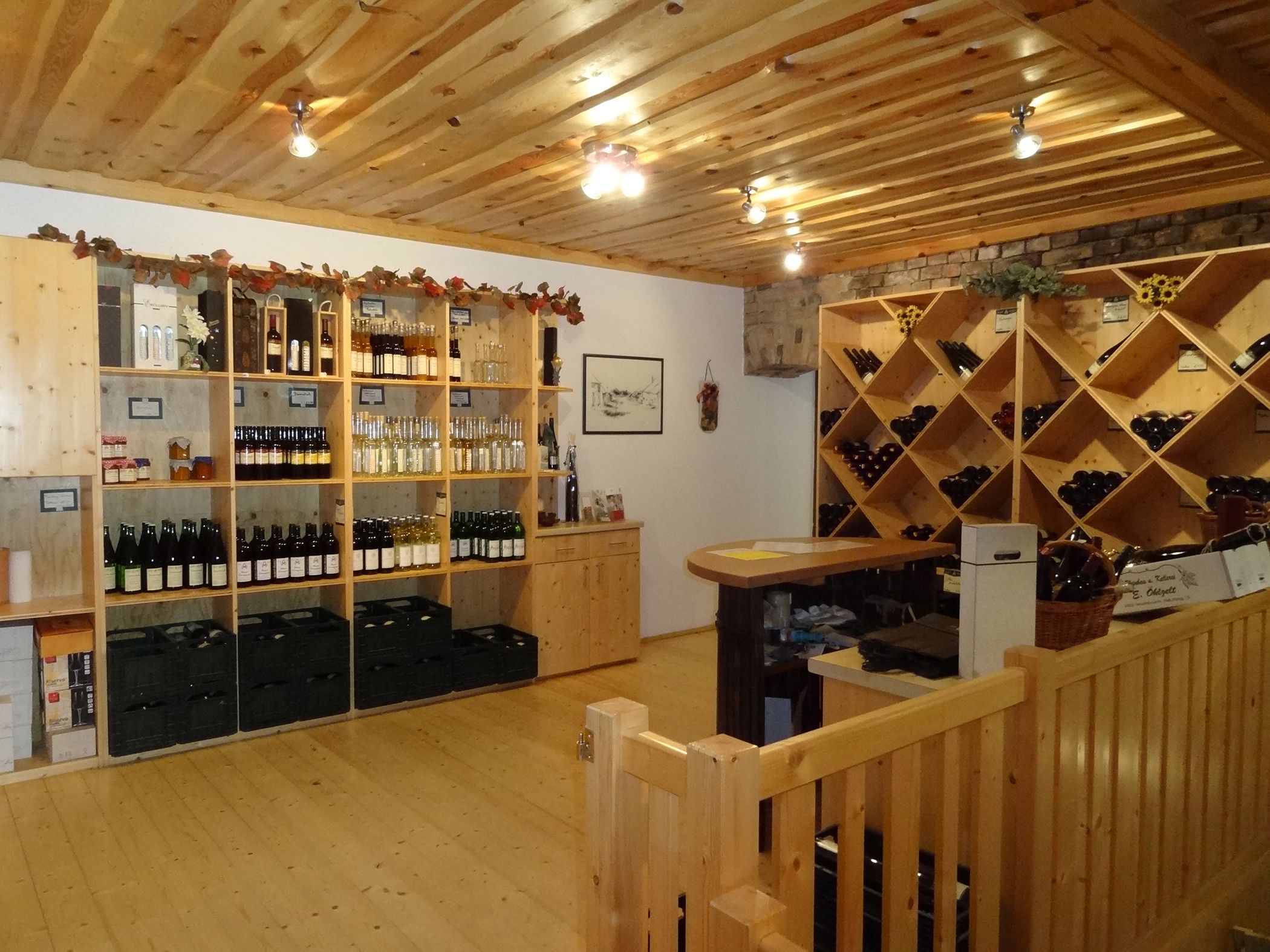 Innenansicht einer Vinothek mit Holzregalen voller Weinflaschen und Spirituosen.