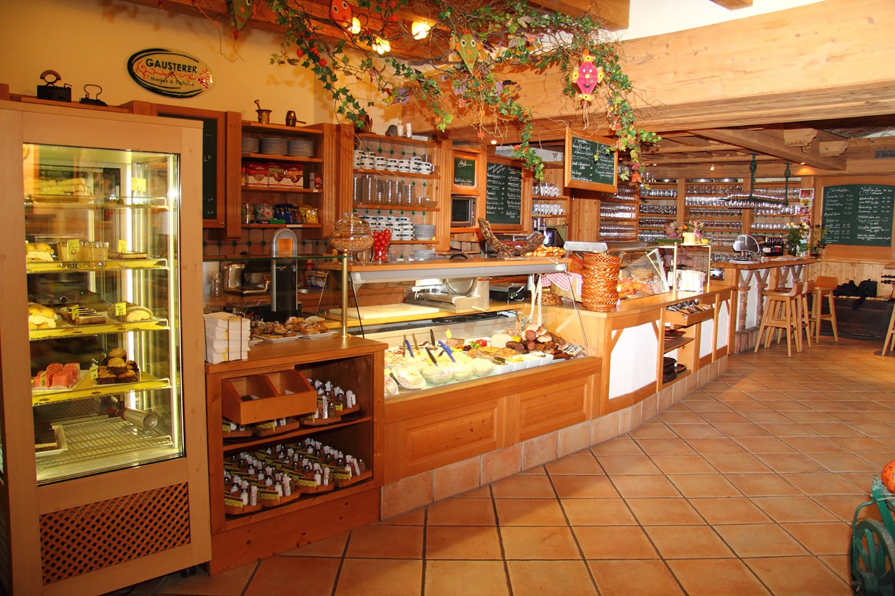 Innenansicht eines gemütlichen Cafés mit Theke und Auslagen.