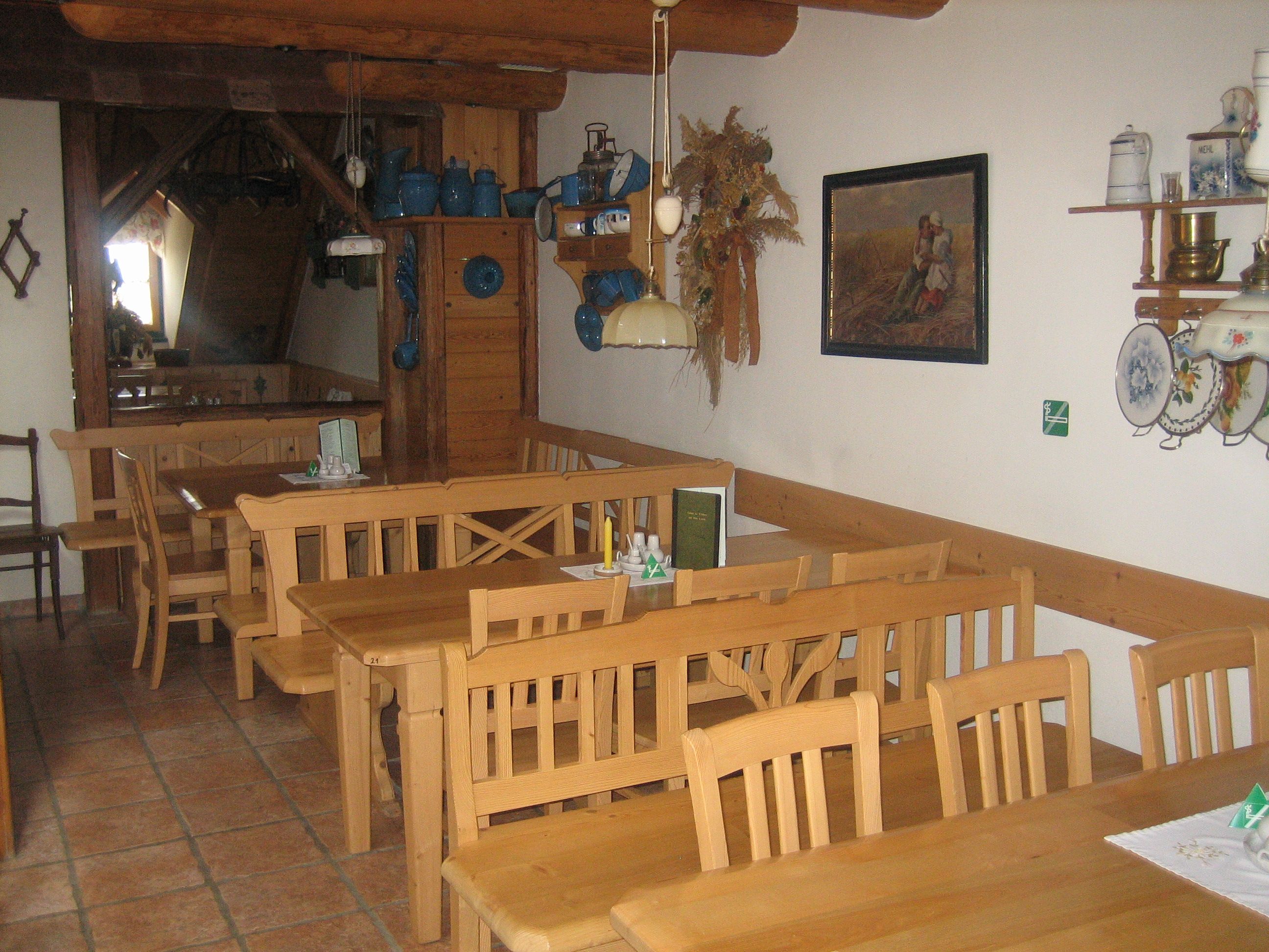 Innenansicht eines traditionellen Gastraums mit Holzmöbeln und rustikaler Dekoration.