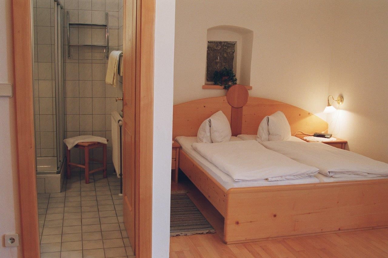 Ein gemütliches Schlafzimmer mit Doppelbett und angrenzendem Badezimmer.