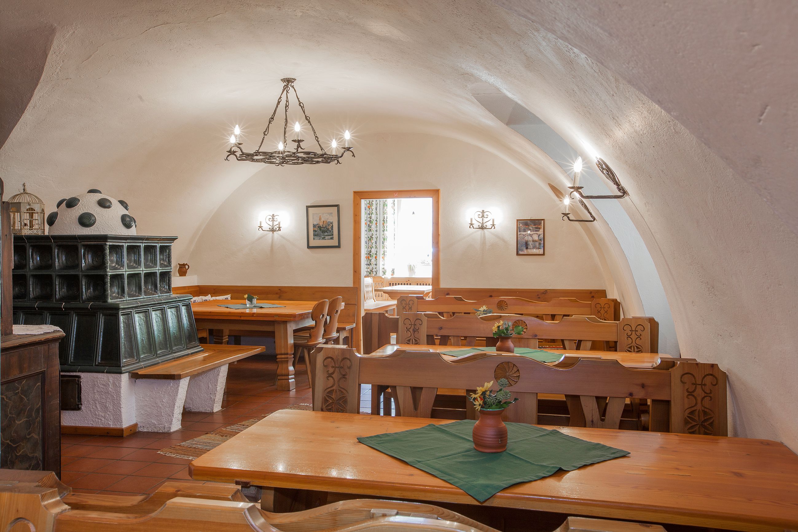 Innenansicht eines traditionellen Heurigenlokals mit Holzmöbeln und Kachelofen.