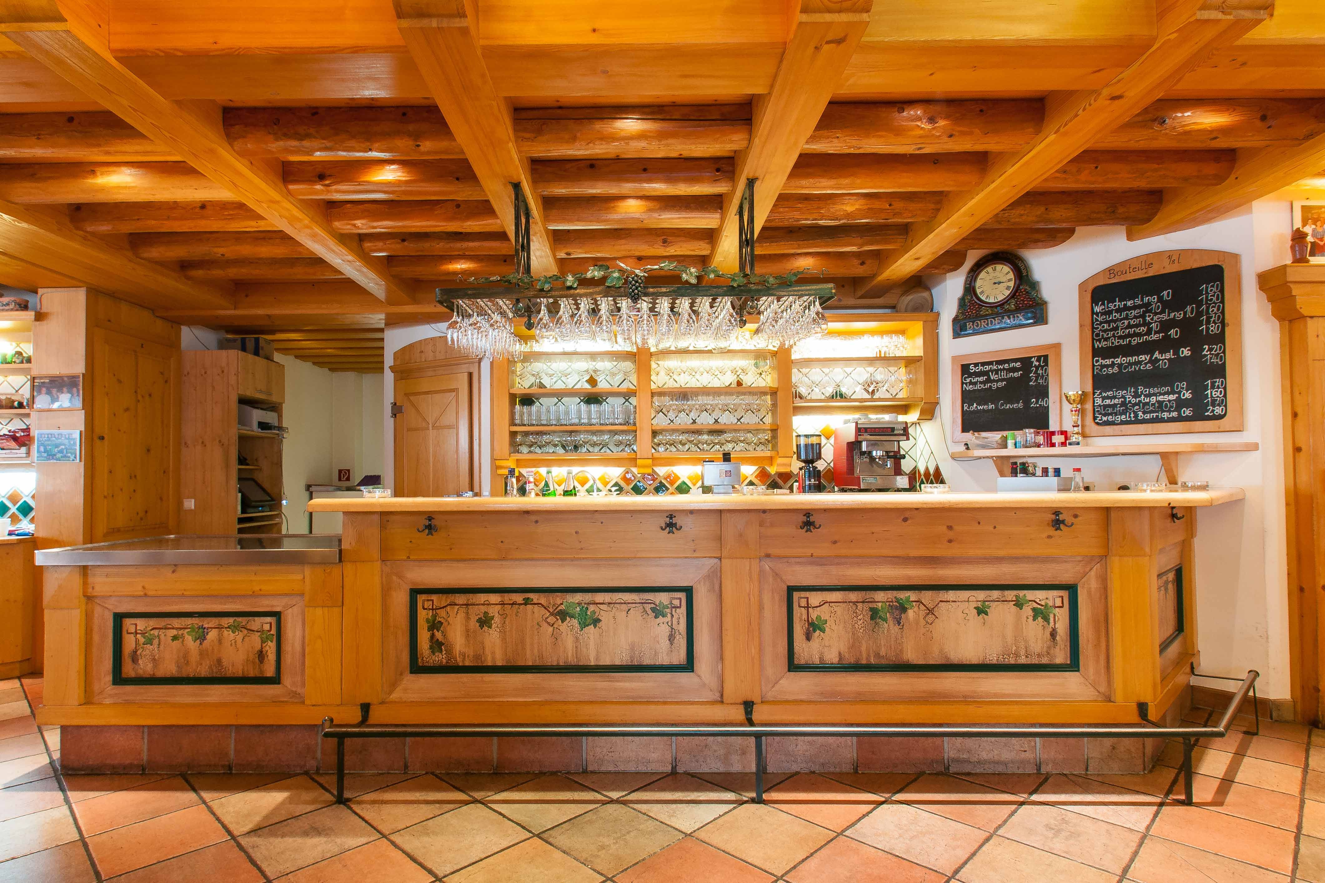 Rustikale Bar mit Holzelementen und Weingläsern an der Decke.