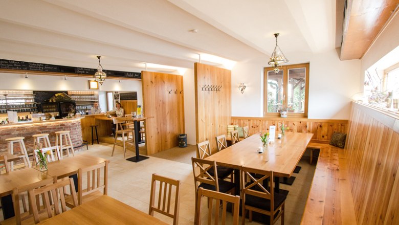 Gemütlicher Gastraum mit Holzmöbeln und Bar.