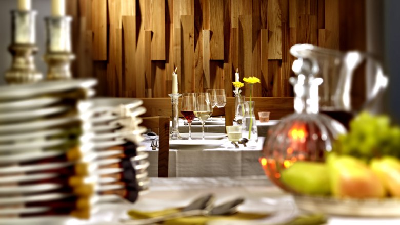 Elegantes Restaurant mit gedecktem Tisch, Kerzen und Weingläsern.