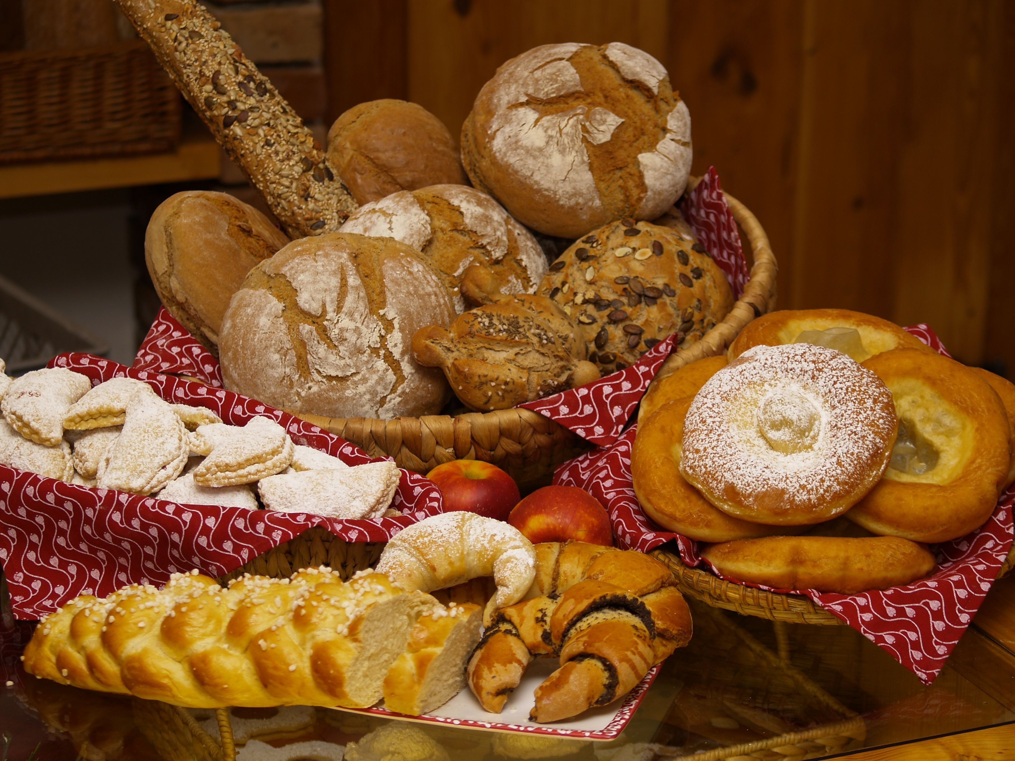 Verschiedene Brote und Gebäck auf einem Tisch, dekoriert mit roten Tüchern.